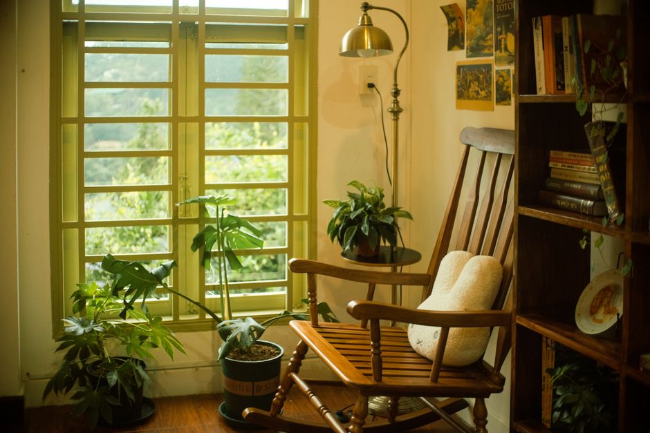 Gezellige leeshoek met houten stoel en vintage decor.